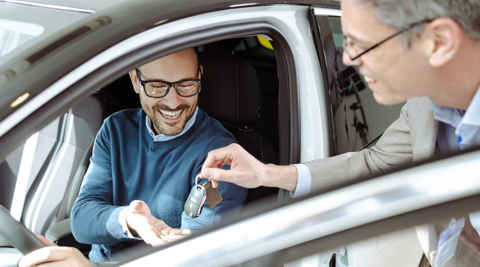 Cliente sorrindo ao receber as chaves de um carro, simbolizando a satisfação após regularizar um carro de leilão.