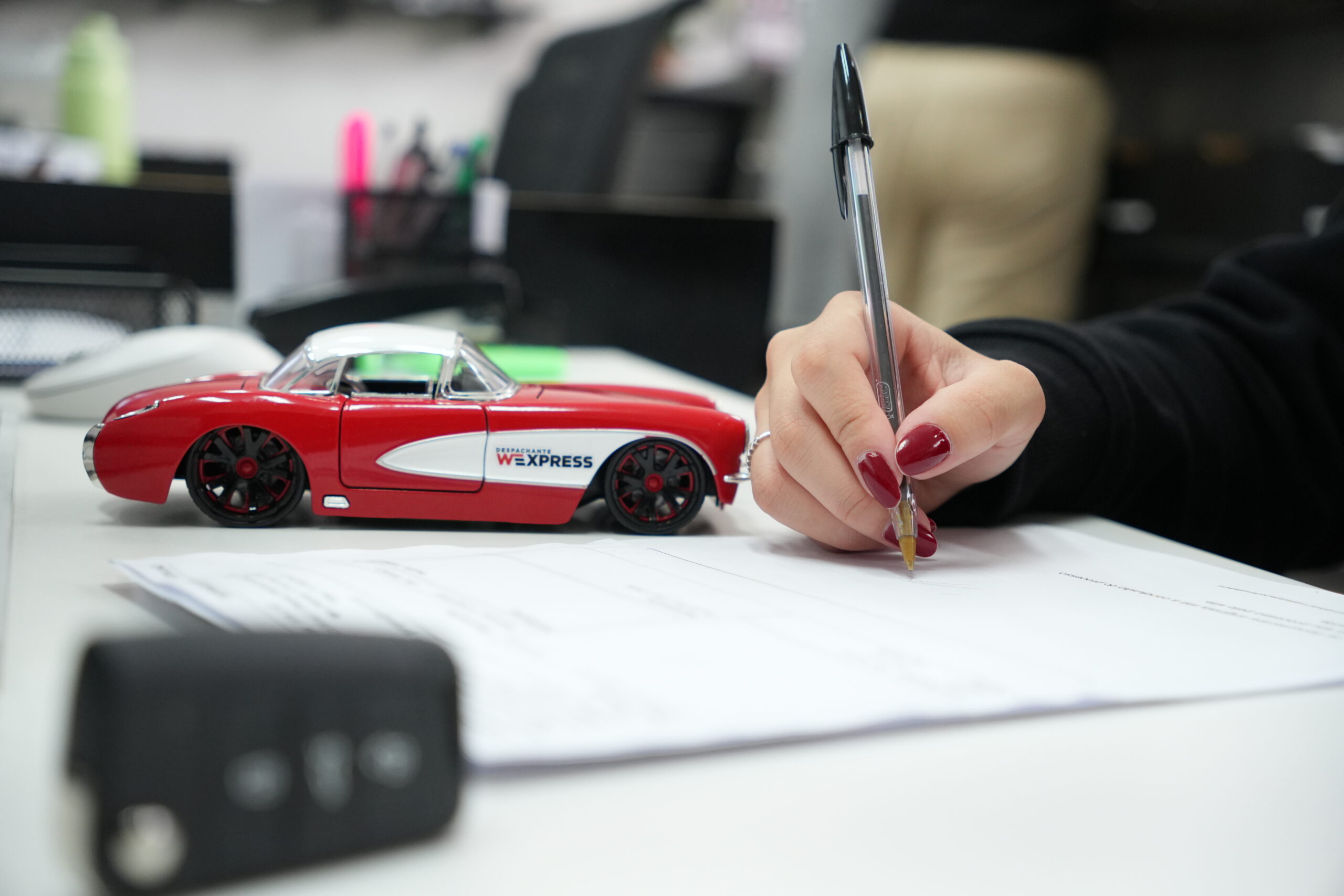 Mulher preenchendo documento com carrinho do WExpress sobre a mesa, simbolizando suporte personalizado e consultoria especializada.